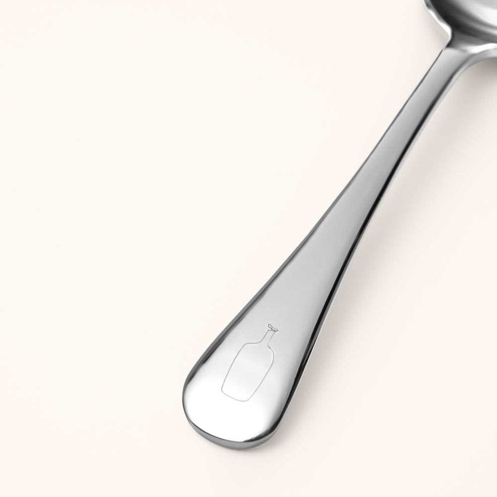 Cupping spoon handle etched with the Blue Bottle logo.